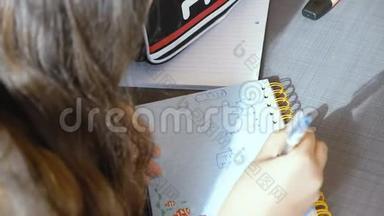 以色列白人少女天才少女在一个<strong>小学班</strong>级的笔记本上写字